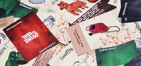 photographie de cartes éparpillées, on peut lire dying to deal au dos de certaines, sur d'autres, on voit une illustration, par exemple un chien, un sac cabas, des lunettes...