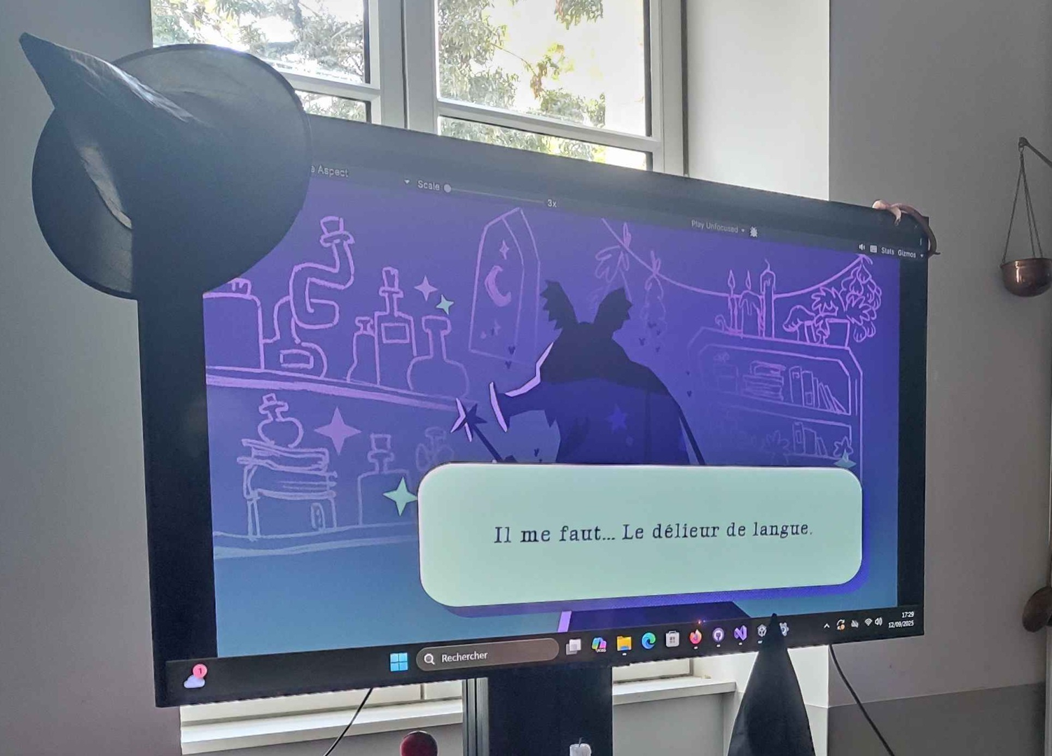 Photographie d'un écran sur lequel on voit un personnage illustré farfelu qui demande le délieur de langue